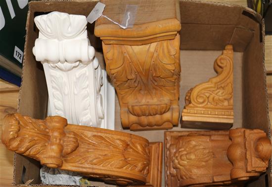 Four carved wood corbels and a similar plaster corbel